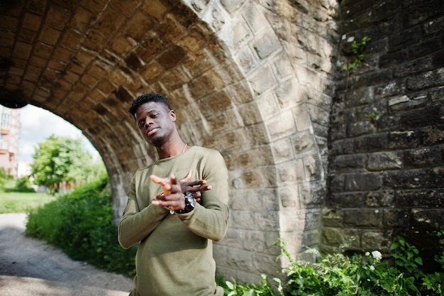 Handsome young african american guy in casual clothing posing and walking in the tunnel