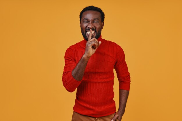 Handsome young African man in casual clothing making a quiet gesture