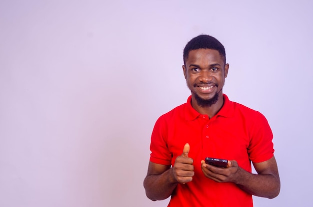 Handsome young african man pointing to his phone screen in excitement