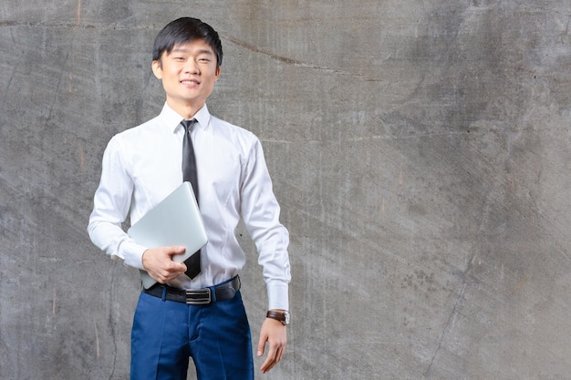 Handsome young asian man standing wearing a suit