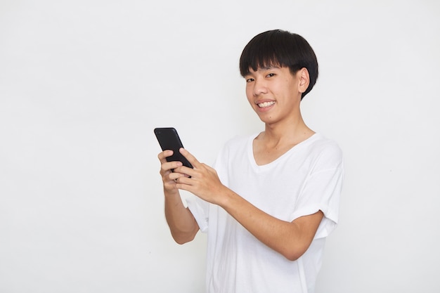 Handsome Young Asian man student texting messages using smartphone on a light surface. Copy space and mockup