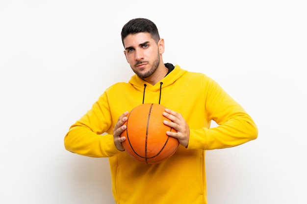 Handsome young basketball player man  on white wall 