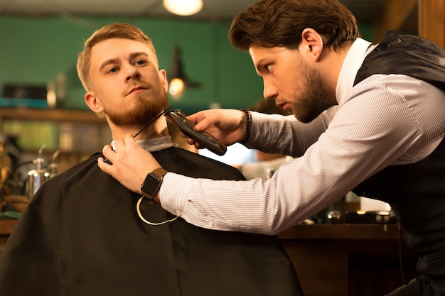 Handsome young bearded man at the barbershop