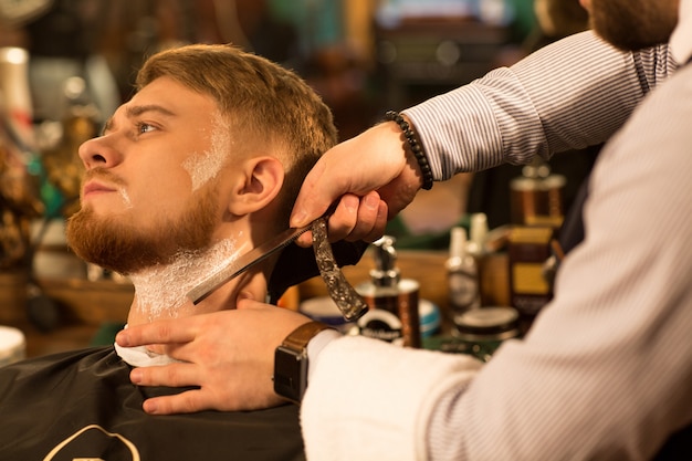 Handsome young bearded man at the barbershop