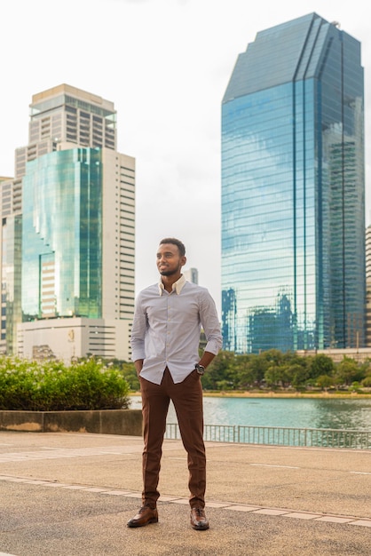 Handsome young black businessman at park outdoors during summer