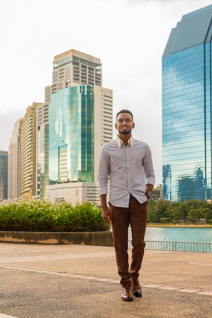 Handsome young black businessman at park outdoors during summer