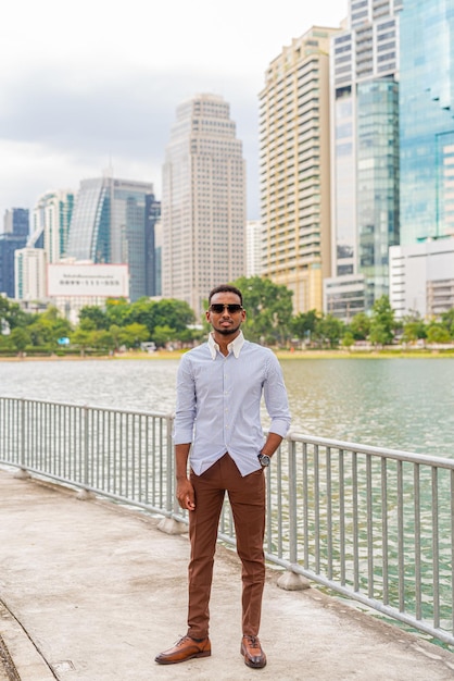 Handsome young black businessman at park outdoors during summer