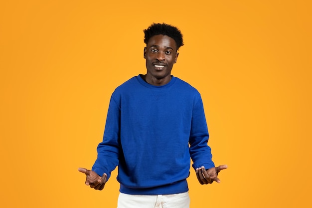 Handsome young black man gesturing on yellow background