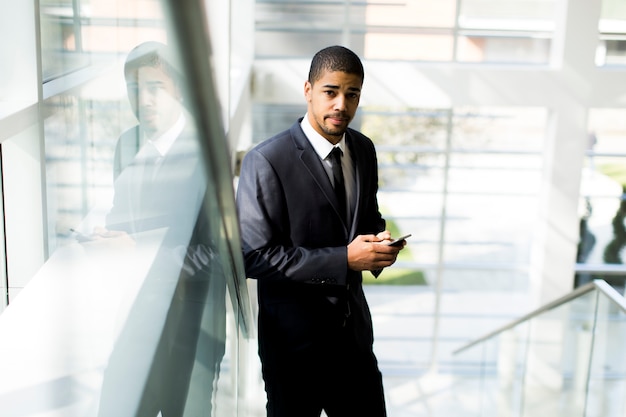 Handsome young black man with mobile phone in the office