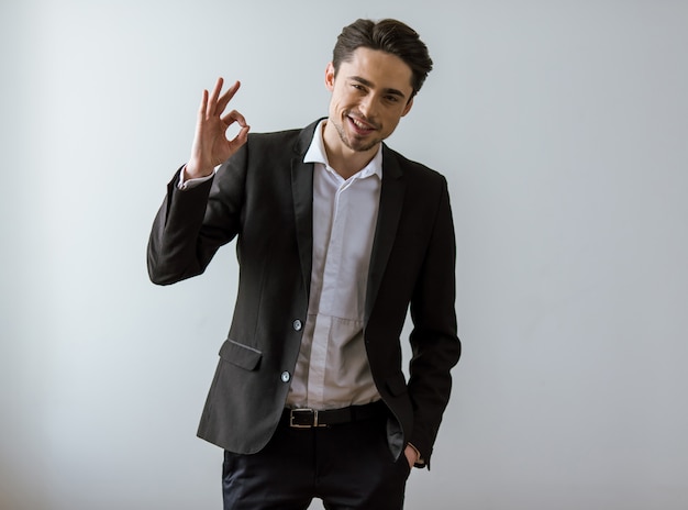 Handsome young businessman in classic suit smiling.