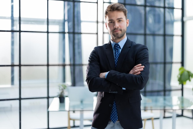 Handsome young businessman standing in modern office