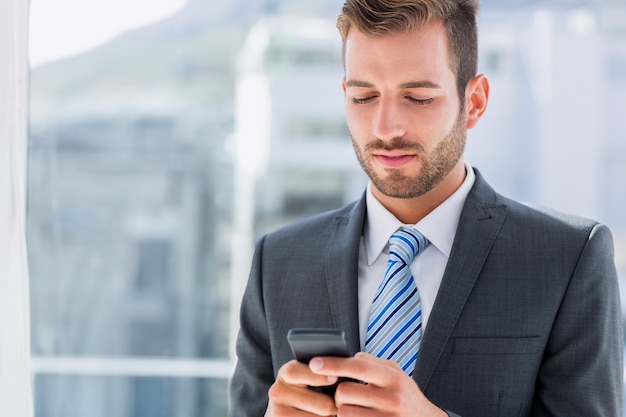 Handsome young businessman text messaging