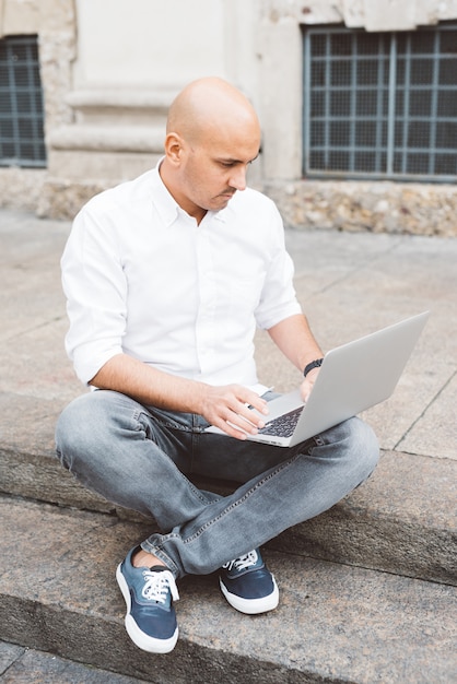 Handsome young businessman in a white shirt working with laptop 