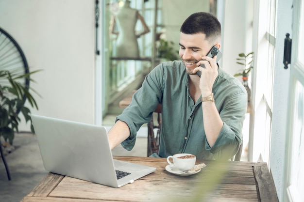 Handsome young businessman Working on laptop and working online while sitting at coffee shop table businessman working outdoors side view