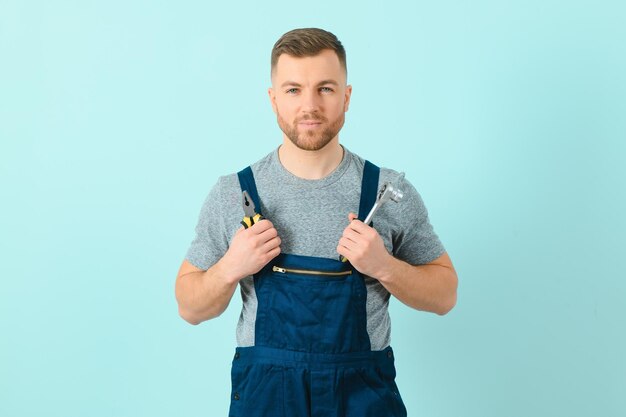 Handsome young craftsman over isolated blue background