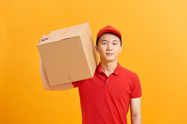 Handsome young delivery man portrait isolated on yellow