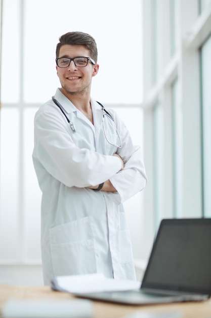 Handsome young doctor portrait in medical office