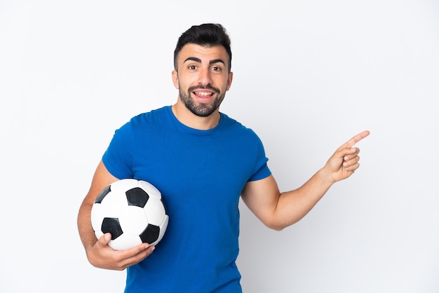 Handsome young football player man over isolated wall pointing finger to the side