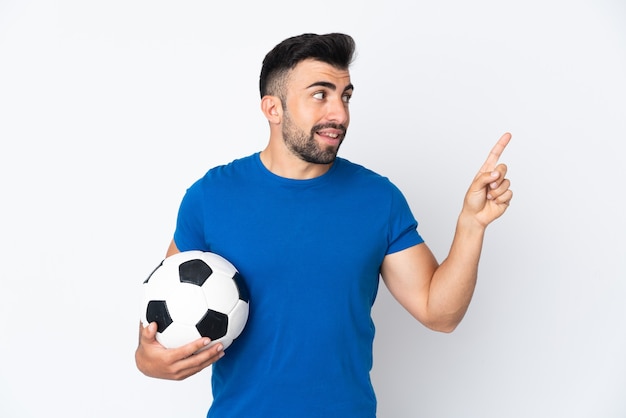 Handsome young football player man over isolated wall pointing up a great idea