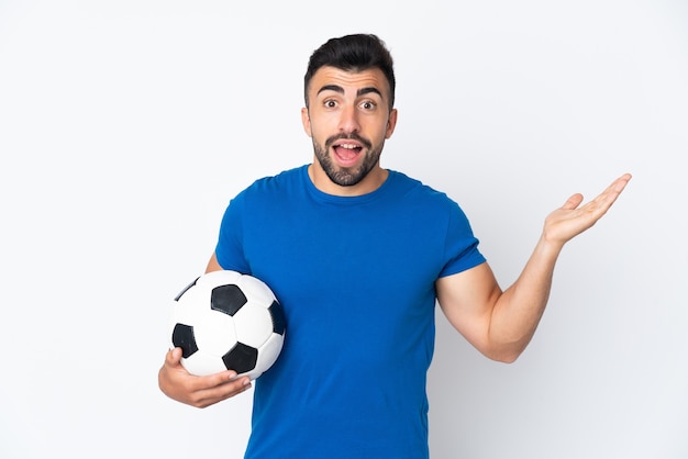 Handsome young football player man over isolated wall with shocked facial expression