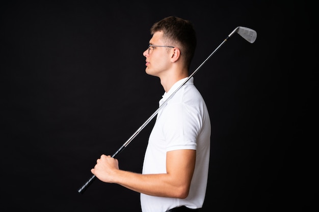 Handsome young golfer player man over isolated black 