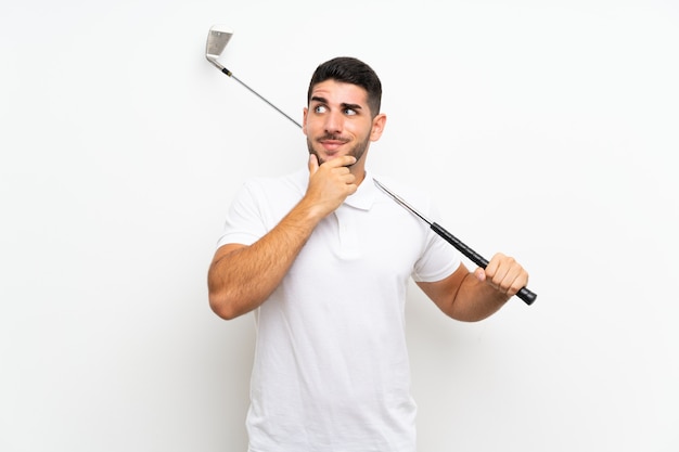 Handsome young golfer player man over isolated white  thinking an idea