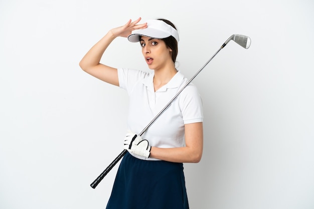 Handsome young golfer player woman isolated on white background doing surprise gesture while looking to the side