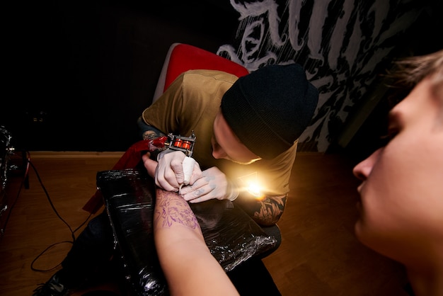 Handsome young guy in a black hat and with tattoos