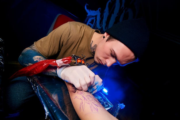 Handsome young guy in a black hat and with tattoos