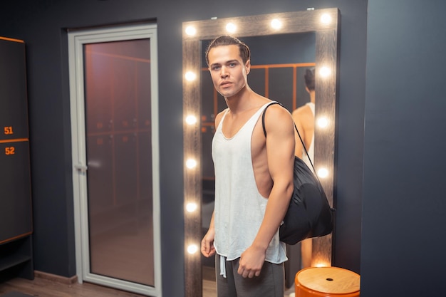 Handsome young man coming to the changing room