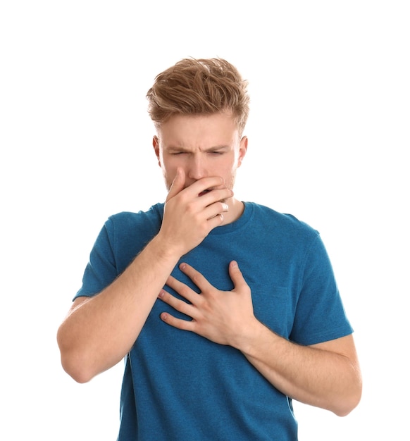 Handsome young man coughing against white background