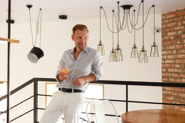 Handsome young man drinking a cocktail inside