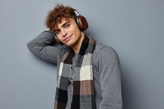 Handsome young man elegant style checkered scarf headphones isolated background