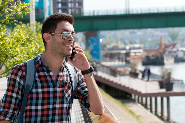 Handsome young man enjoys a mobile phone sitting on the stairs.