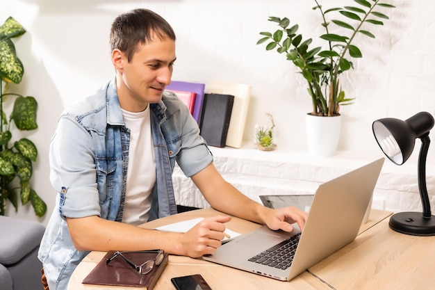 Handsome young man online using a laptop