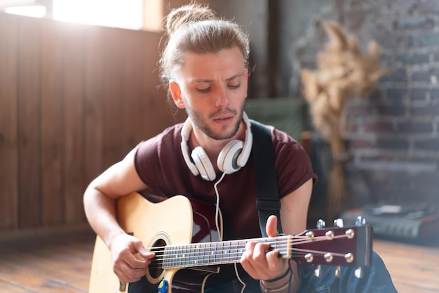 Handsome young man playing acoustic guitar