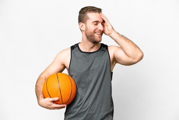 Handsome young man playing basketball over isolated white background smiling a lot