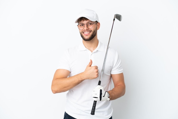 Handsome young man playing golf  isolated on white background giving a thumbs up gesture