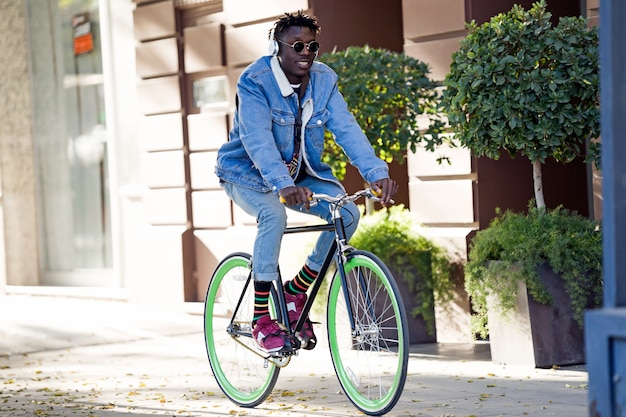 Handsome young man riding bike in the street.