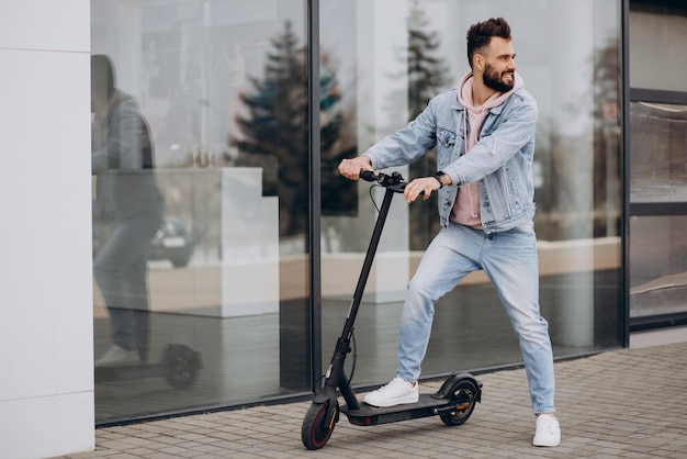 Handsome young man riding electric scooter