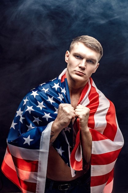 Handsome young man's torso covered with american flag.