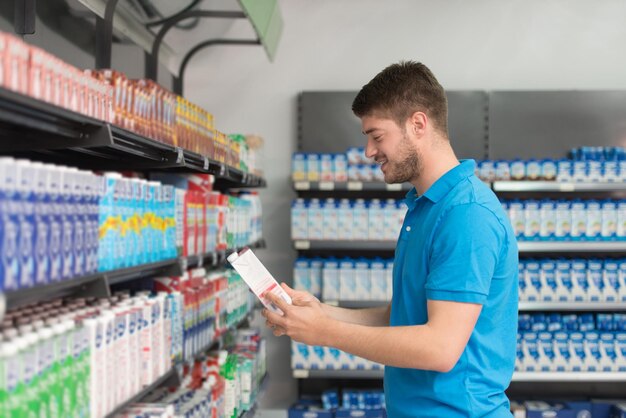 Handsome Young Man Shopping For Milk And Cheese In Produce Department Of A Grocery Store  Supermarket  Shallow Deep Of Field