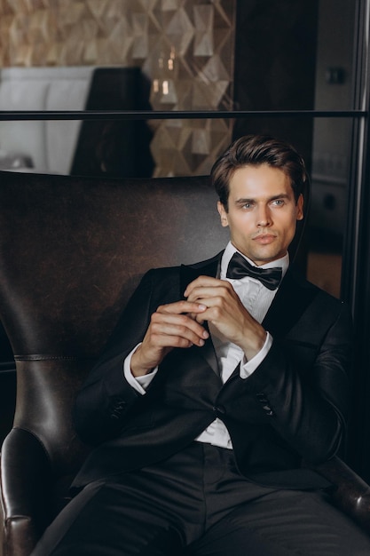 Handsome young man sitting on chair Fashionable Clothing Clothing for the festive evening