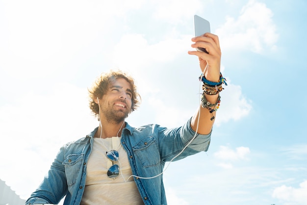 Handsome young man take a picture selfie in the street.