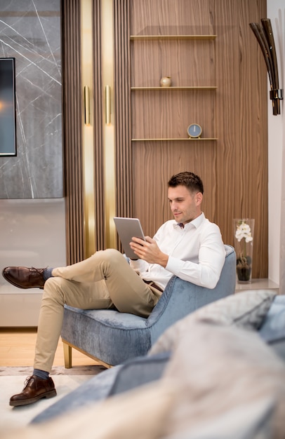 Handsome young man using digital tablet at luxury apartment