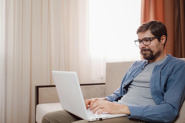 Handsome young man using laptop computer at home