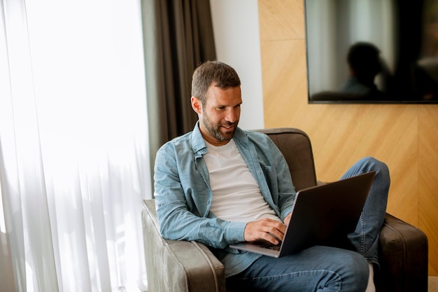 Handsome young man using laptop computer in the living room