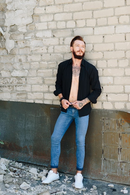 A handsome young man with a beard in a grunge-style interior