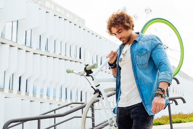 Handsome young man with fixed gear bicycle in the street.