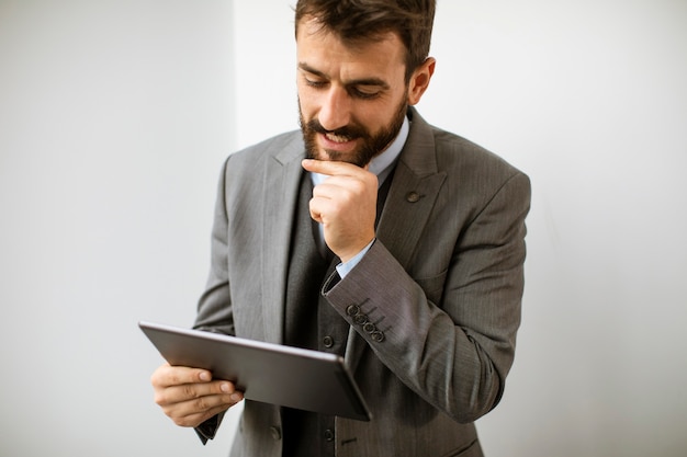 Handsome young modern businessman using digital tablet in the office